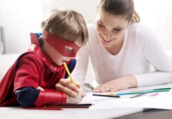 boy dressed in costume doing school work with mom